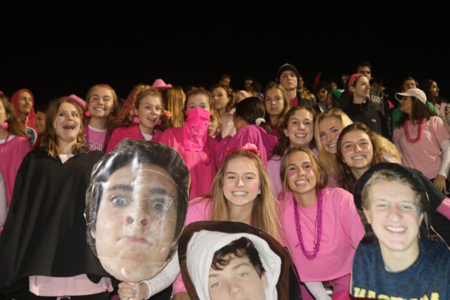 Seniors bring big heads and big school spirit to pink out last Friday night.