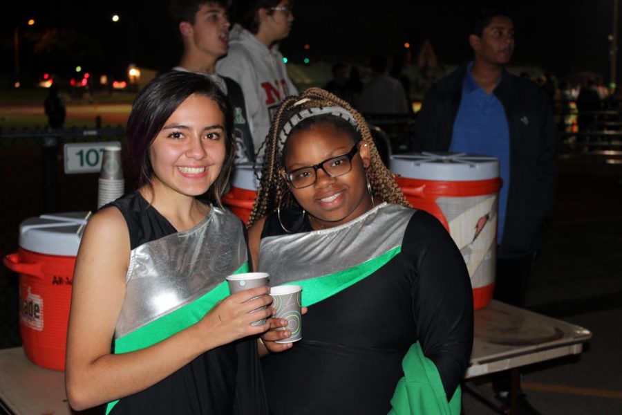 Sophomores Shaniya Watkins and Citlaly Herculano warm up with hot chocolate. [Student Council should do this next year] because we need it, Watkins said. In Color Guard, we get so cold [in October.]