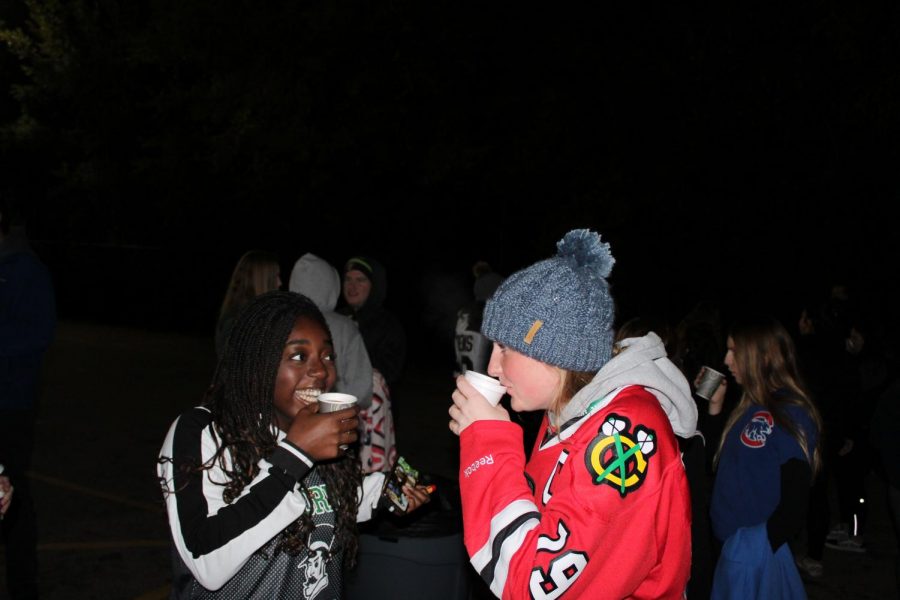 Seniors Darelle Menendie and Cassie Sika enjoy their hot chocolate. The hot chocolate just added to my already memorable last home game, Menendie said.
