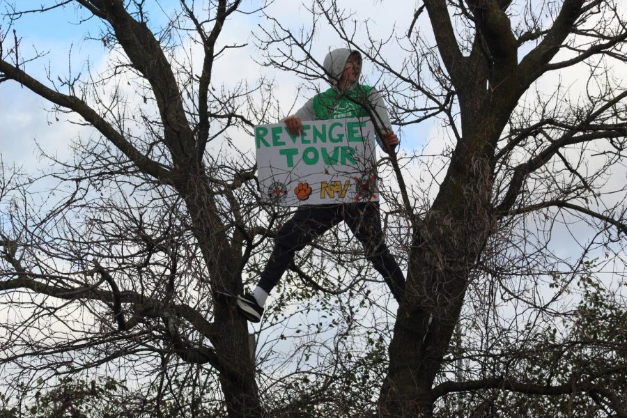 A fan displays the revenge tour sign for all to see by climbing a tree. Saturday, November 2, 2019.