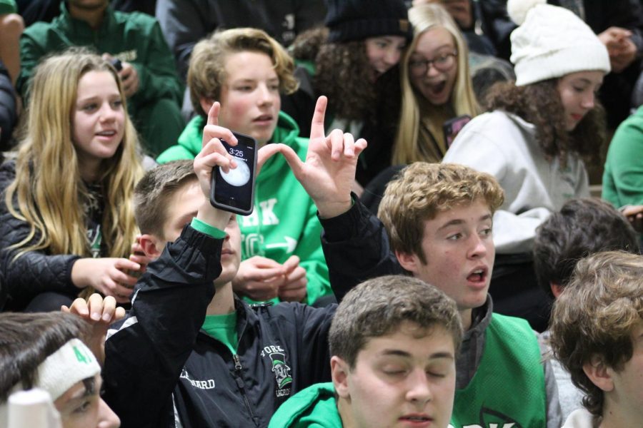 A fan makes a W symbol with his hands signifying the win for the boys team.