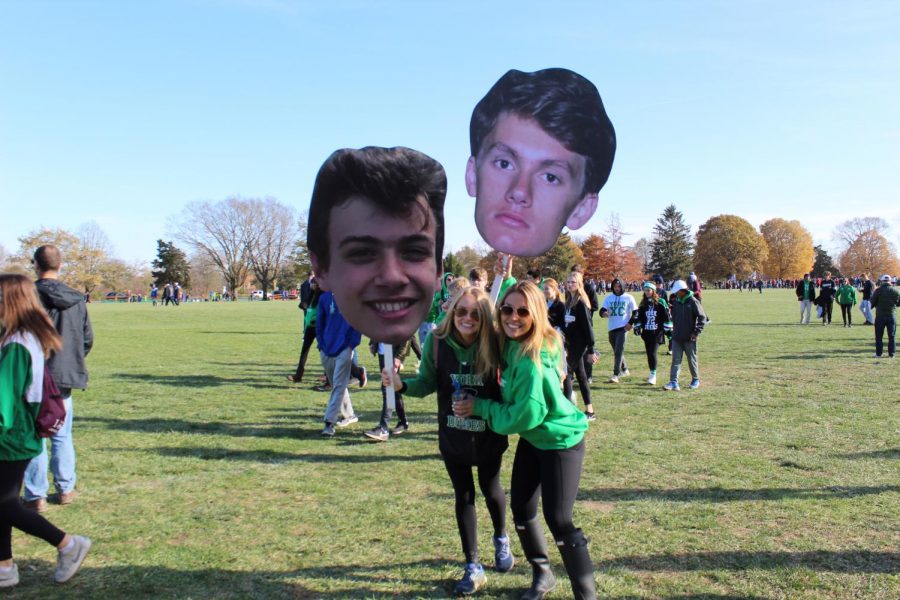 Seniors Emma Fahey and Ariel Kimbler pose with the fat-heads of varsity runners Colin Hill and Daniel Klysh prior to the race. November 9, 2019.