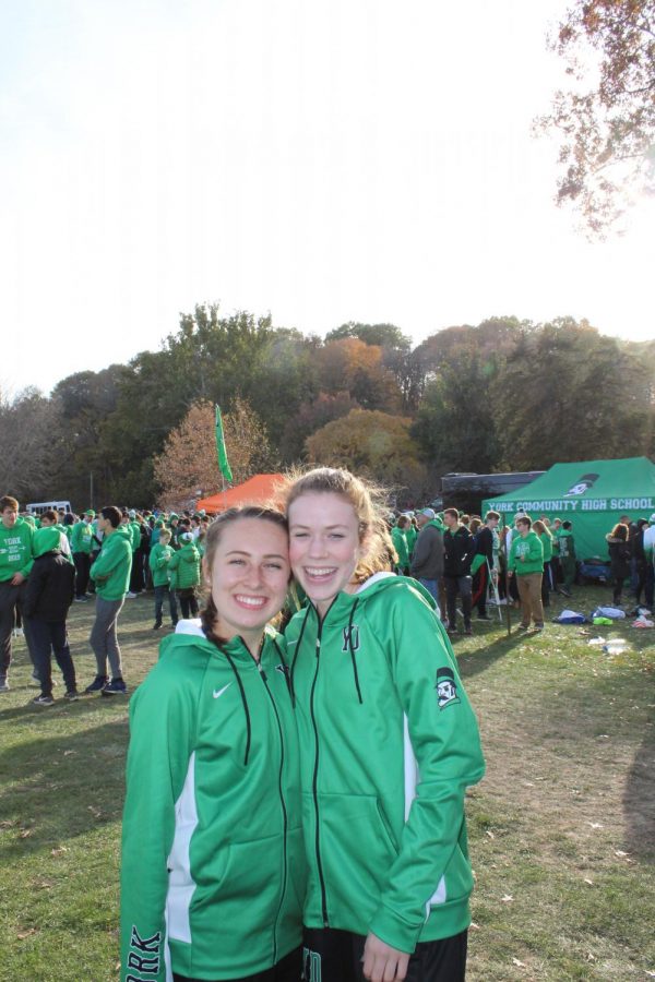 Seniors Maggie Clink and Lydia Hickey pose in front of the crowd after both the girls and boys races finished. November 9, 2019.