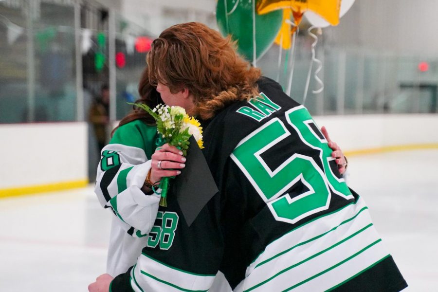 Captain Jack ray delivers a flower to his mother on senior night.
