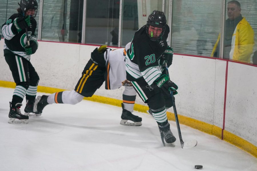 Senior Nathan Kriz carries the puck along the boards.