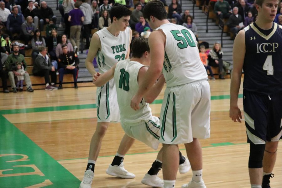 Senior Nate Shockey gets some help from his teammates, senior Tim Glavan and sophomore Nick Hesch, following drawing a foul.