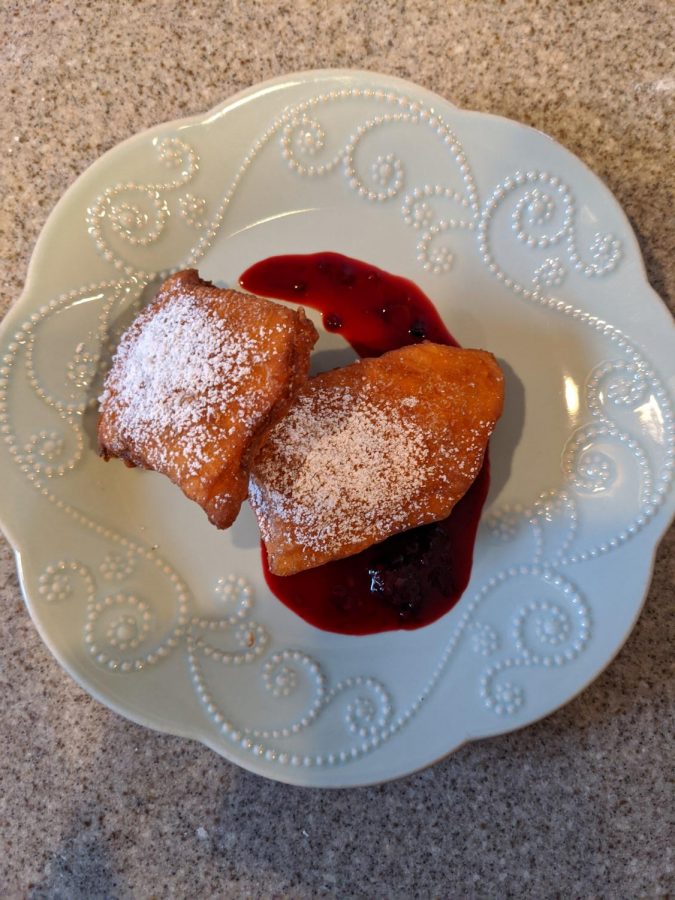 Once the sauce and beignets are done,  plate the beignets with the sauce. Make a dash of sauce across a plate and set the beignets on top. 
