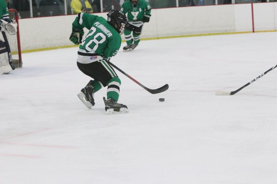 Sophomore Bobby Plummer skillfully stick handles the puck in an attempt to exit the defensive zone.