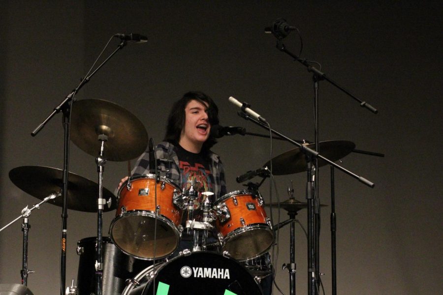 Freshman Aiden Costanzo sings and plays the drums during his bands performance ofGreen Days Welcome To Paradise.  It’s a really fun experience because music is hard to share out of a specific context, Costanzo said. “I know that because it’s a really big part of my life and not a lot of people know that. It’s really nice to see other people who I may not have necessarily known as dancers or singers or performers.”