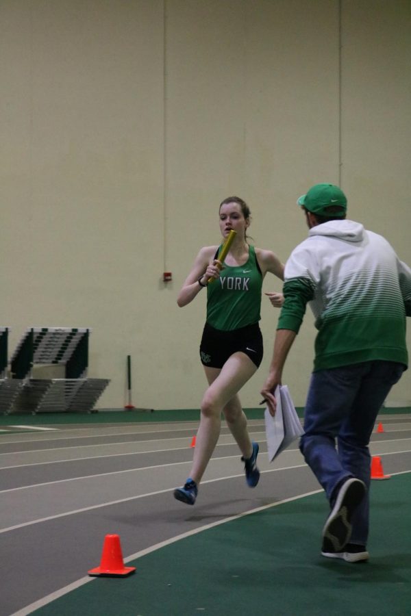 Senior Abby Moriarty is encouraged by her coach, Jimmy Kolb, as she races in the varsity 4X800m relay.