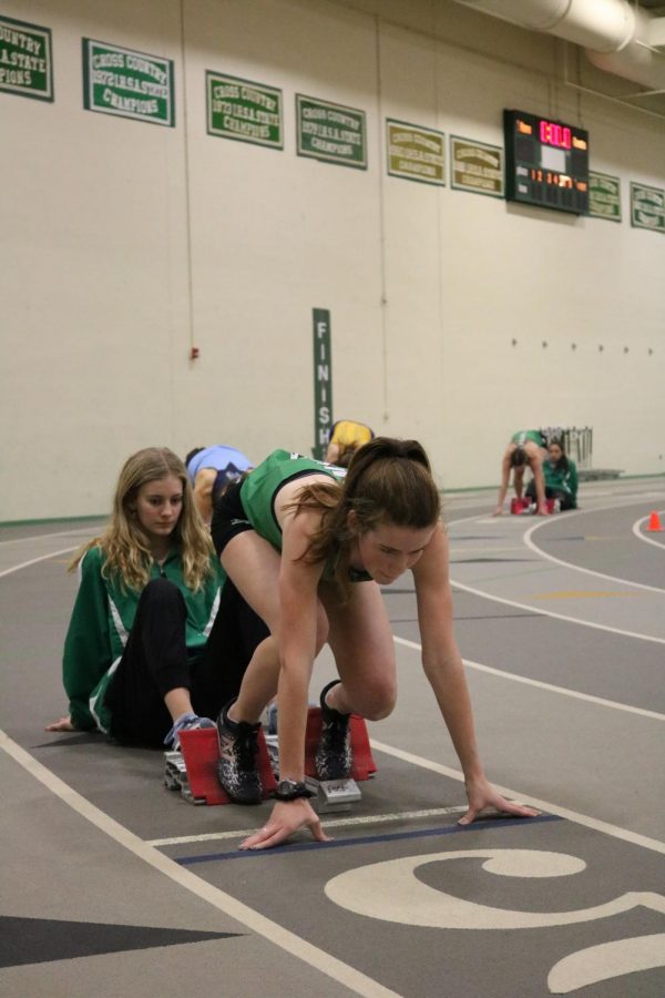 Senior Lydia Hickey sets herself up in her blocks as she prepares for the varsity 400m dash.