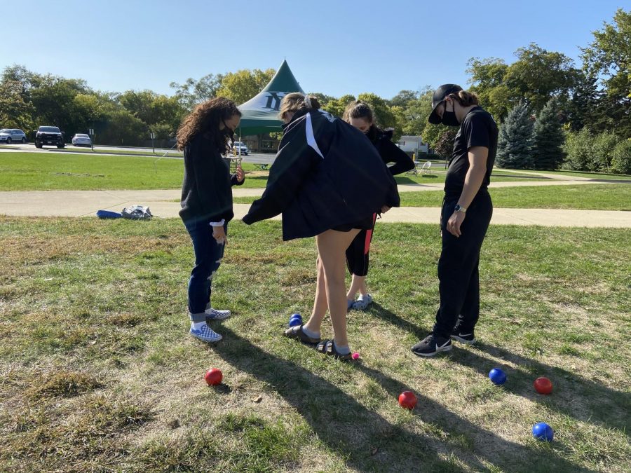 Juniors Reese Krauter, Co-President Maria Chornij, Cayliann Gillie and senior Ricky Pesek measure the distance of their bocce balls from their target to determine a winner. 