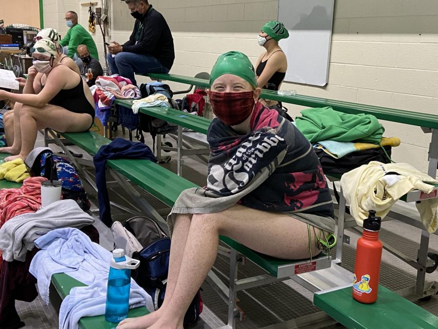 Senior Mallori Hecker wears a mask, and a smile, as she dries off on the stands and supports her teammates from the sidelines.