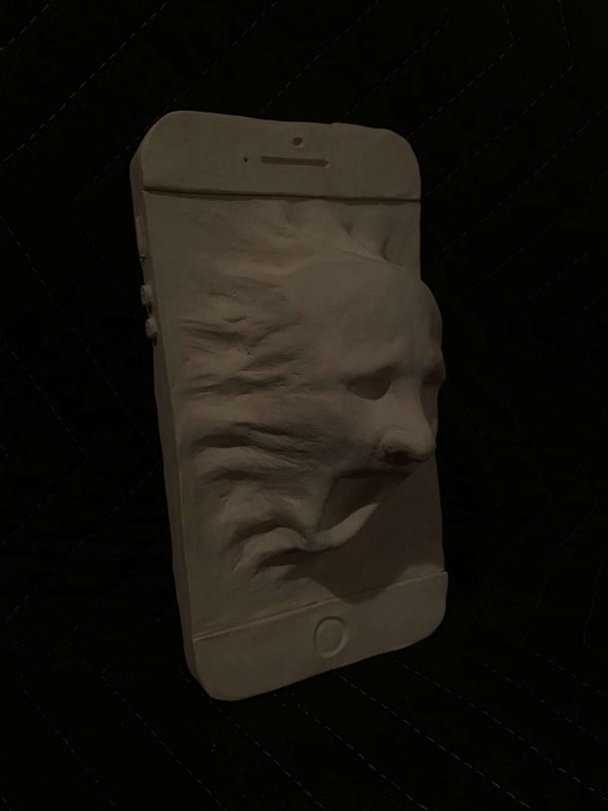 Photo of Matthew Milani's artwork for AP Art. Milani created a clay sculpture of a screaming face coming out of a phone in theme with his chosen sustained investigation, which depicts the relationship between people and technology.