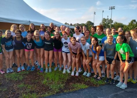 The girls cross country camp gathered before their morning practice in a tent located in Berens Park, where they prepared to complete their run. July 1, 2021.