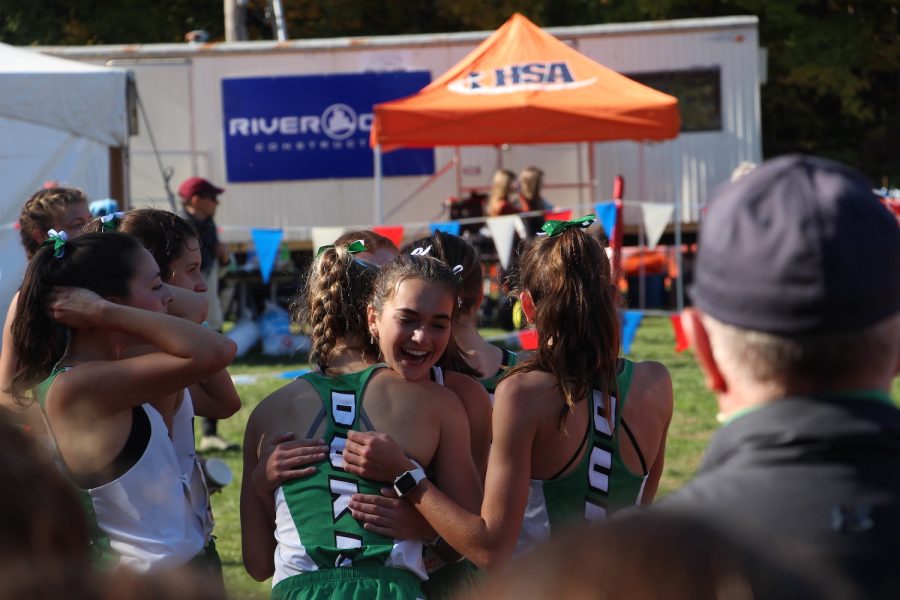 Junior Bria Bennis embraces senior and fellow teammate Katelyn Winton and sophomore Michaela Quinn after finishing the race. “It was such a happy feeling to be all together and knowing that we all did so well” said Bennis. November 6th, 2021
