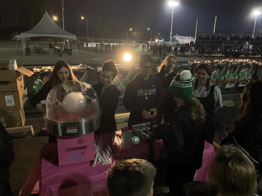 Make a Wish Club members Eliana Hollis, Veer Sule, Brooklyn Nuss, Elena Papaioannou, and Francesca Monteleone serve cotton candy to people in the crowd during the second quarter of the Glenbard West v York football game. Photo courtesy of Eliana Hollis