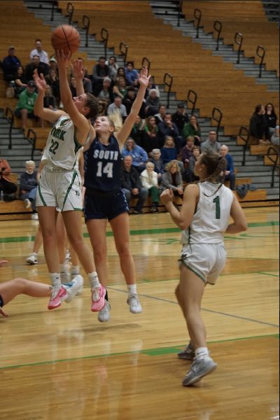 Stella Kohl, senior, getting away from the DGS defender and going up for the layup. Cate Carter, freshmen, looking to help.