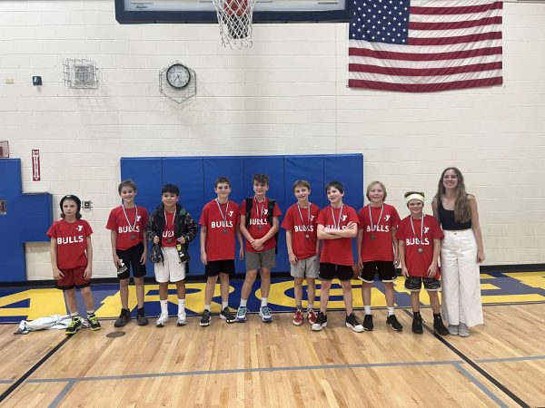 Schultz (far right) standing with the sixth grade YMCA boys basketball team she coached after a loss in the championship game.