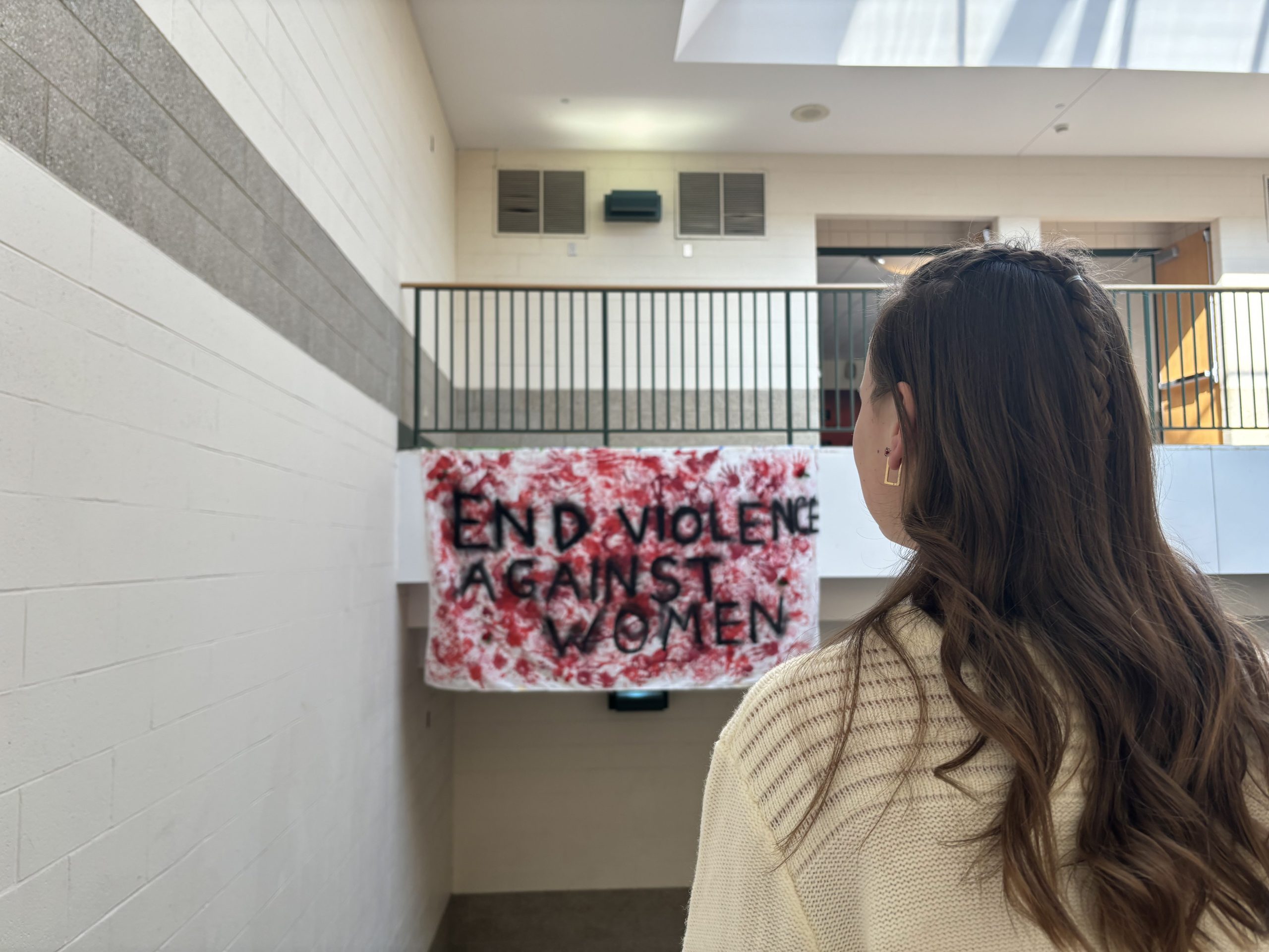 A student looks ahead at the large display, promoting an end to violence against women on Valentines Day