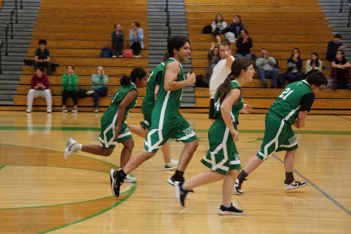 Teammates celebrate a basket in the Student vs. Staff game.