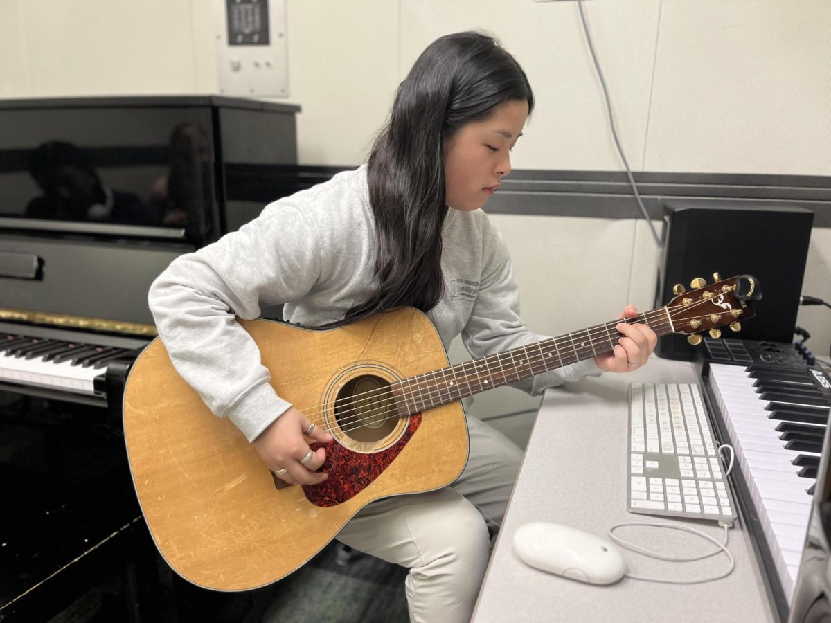 Junior Alyssa Korkowski practices her guitar for her York Live duet.